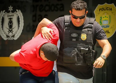 Marcos Rios sendo conduzido pelos policiais do DHPP