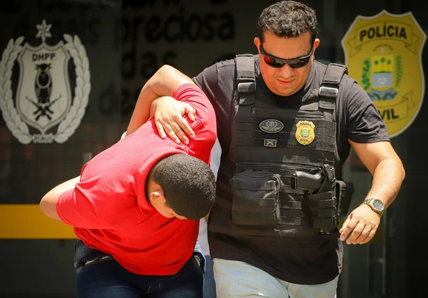 Marcos Rios sendo conduzido pelos policiais do DHPP