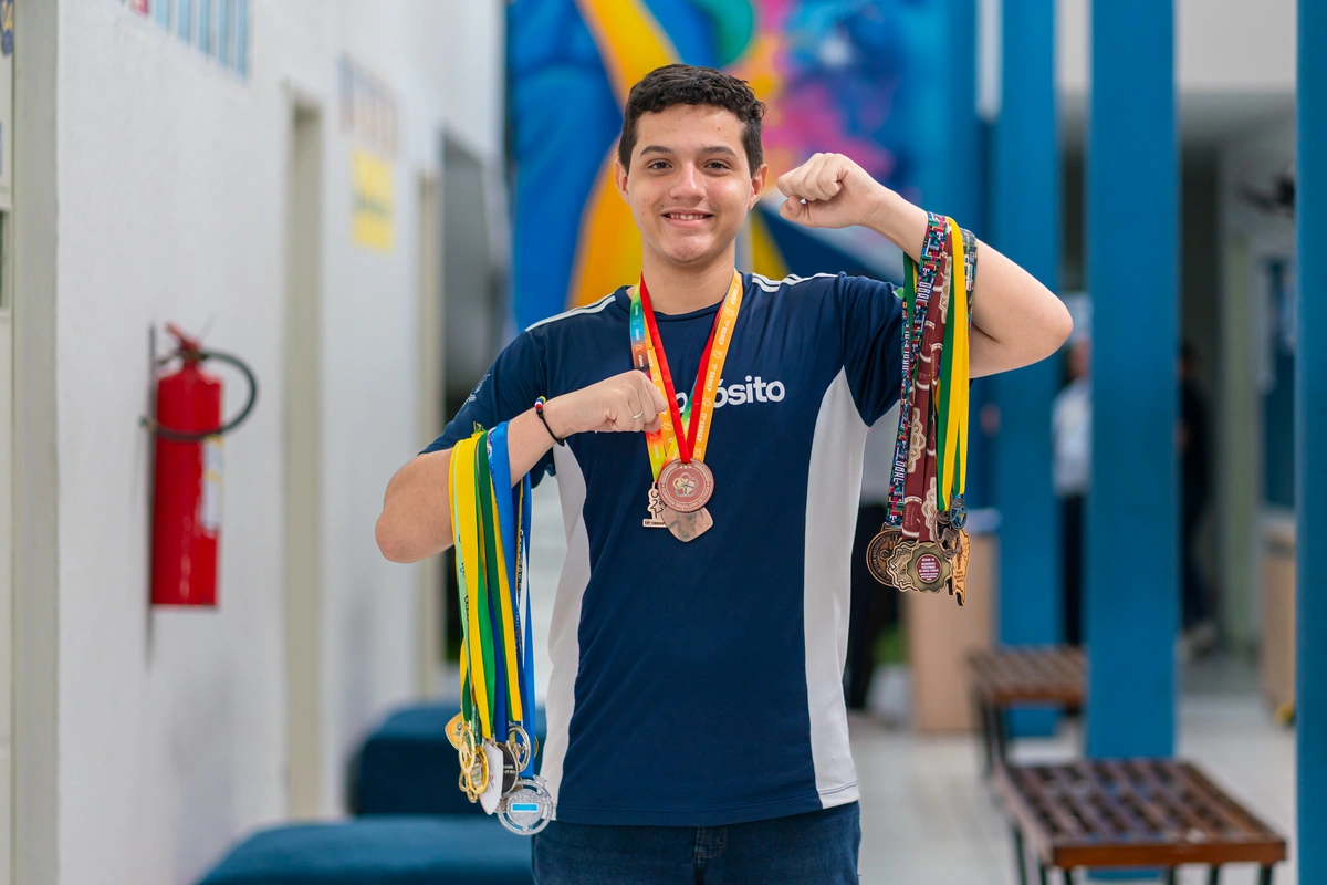 O estudante com suas medalhas, símbolo de dedicação e paixão pela ciência