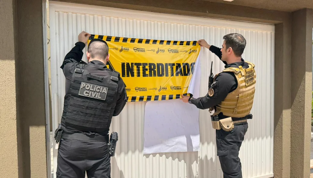 Policiais interditando a casa