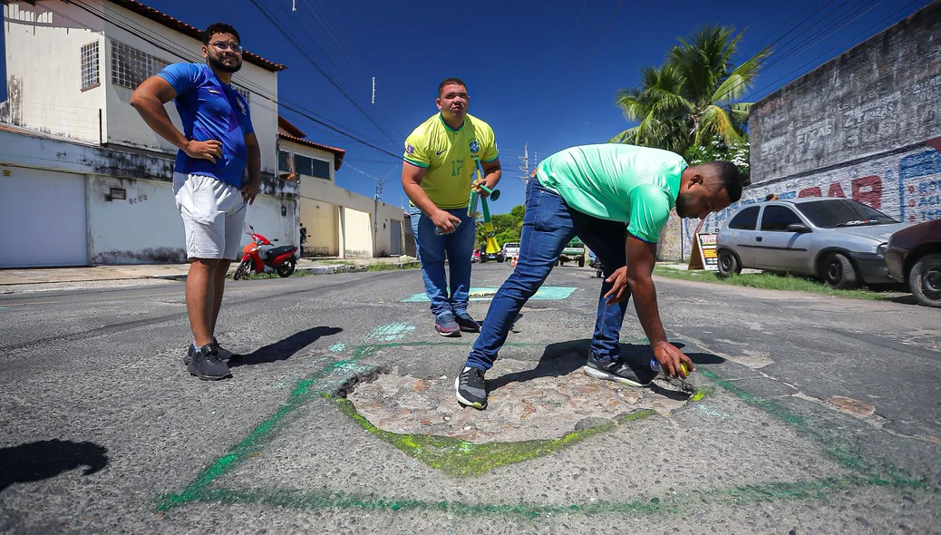 Moradores pintando a via