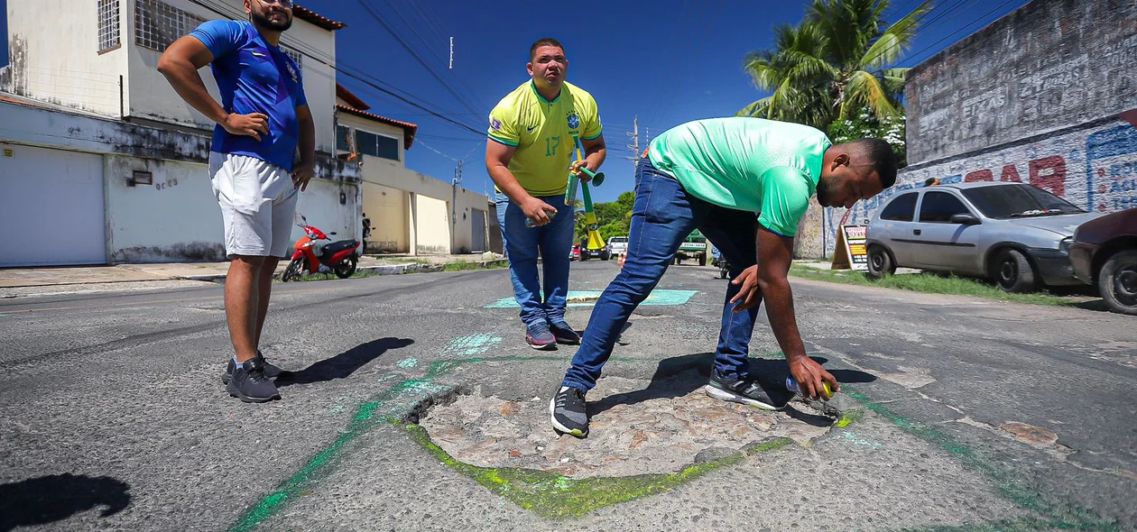 Moradores pintando a via