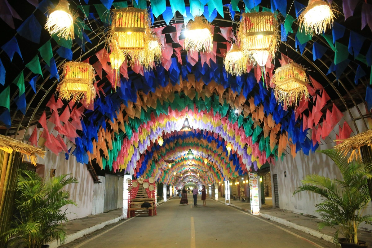 Rua decorada com bandeirolas coloridas e luminárias de palha anuncia o clima festivo do XXI Festival Cultural dos Cocais em São João do Arraial