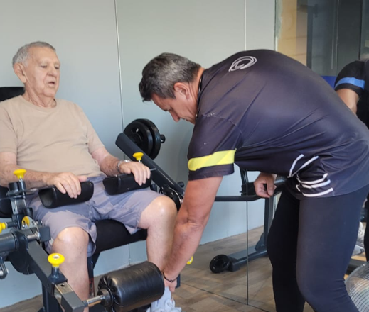 O Sr. Edmilson Nogueira (90 anos) fazendo musculação terapêutica com o prof. Demóstenes