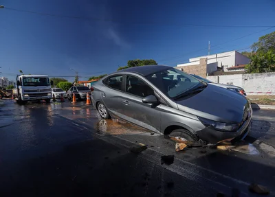 Veículo HB20S ficou preso na cratera que se abriu após vazamento da Águas de Teresina