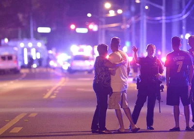 Policial orienta família a ficar longe da boate alvo do atirador em Orlando, nos Estados Unidos 