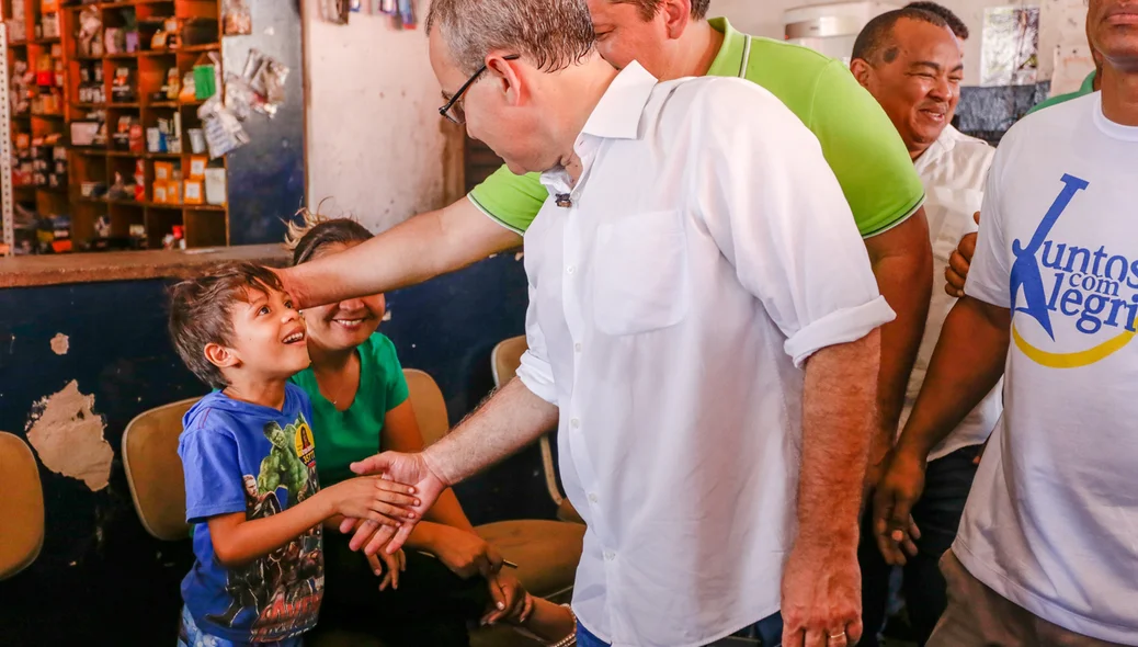 Prefeito cumprimenta criança durante sua caminhada