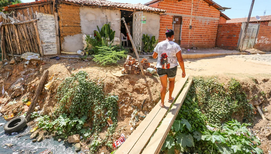 Moradora atravessa ponte para chegar em sua residência