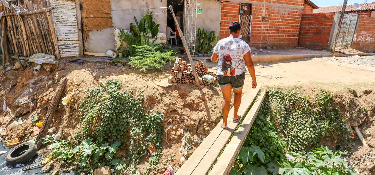 Moradora atravessa ponte para chegar em sua residência