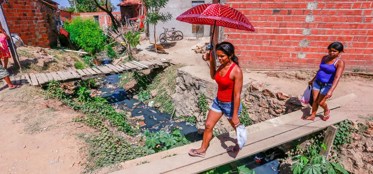 Moradores atravessam ponte feita por moradores para chegar em suas residências