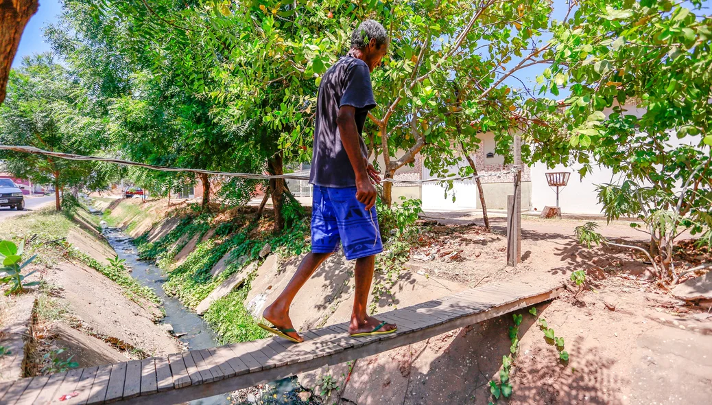 Os moradores fizeram uma ponte de madeira para atravessar a galeria