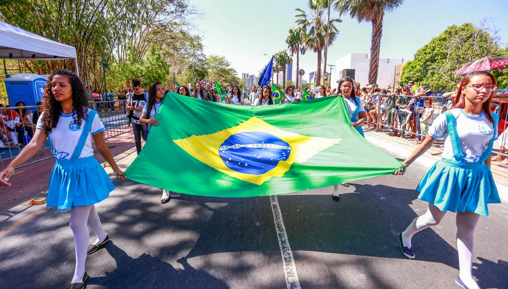 Jovens carregando a bandeira do Brasil