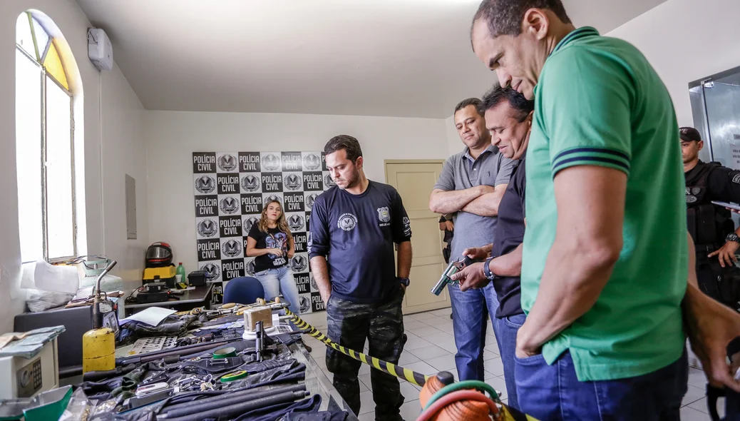 Carlos Césa, Riedel Batista e Fábio abreu observando objetos e armas apreendidas na operação
