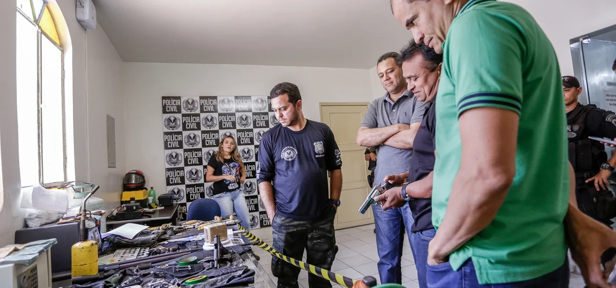 Carlos Césa, Riedel Batista e Fábio abreu observando objetos e armas apreendidas na operação