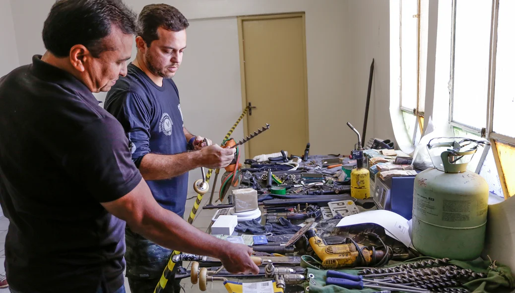 Fábio Abreu e Carlos César observando armas,drogas e armas apreendidas