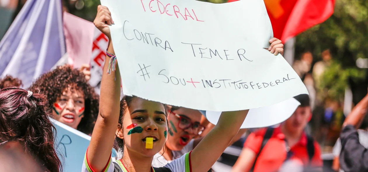 Aluna  levanta cartaz em sinal de protesto