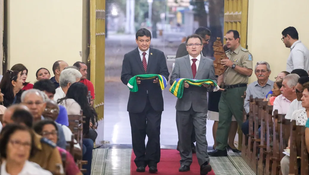 Wellington e Merlong carregam bandeiras para o altar