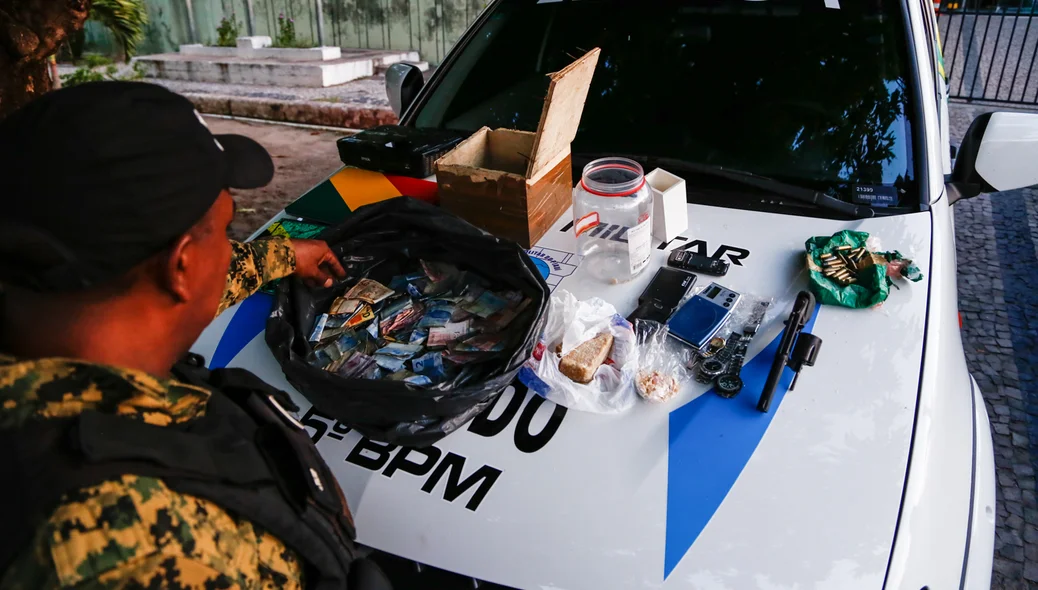 Policial Militar contanto dinheiro apreendido 