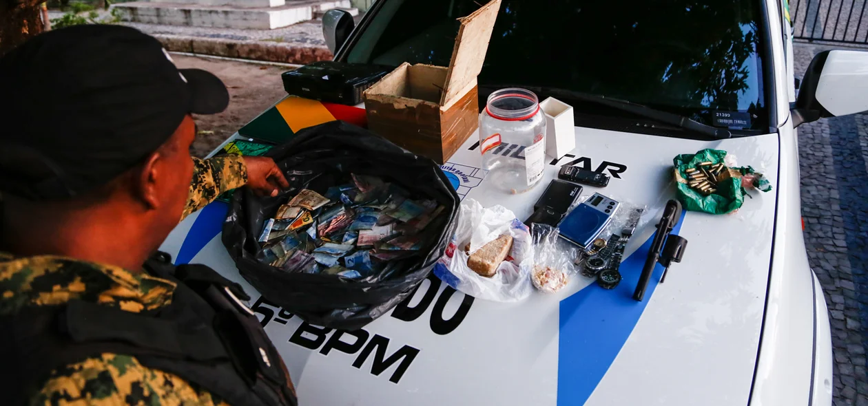 Policial Militar contanto dinheiro apreendido 