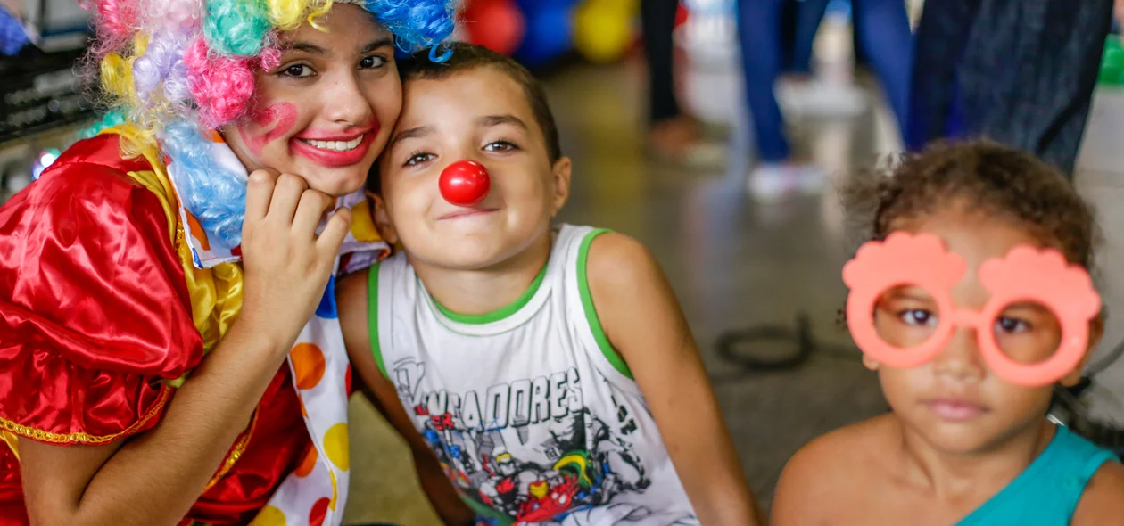 Crianças tirando foto com a palhaça