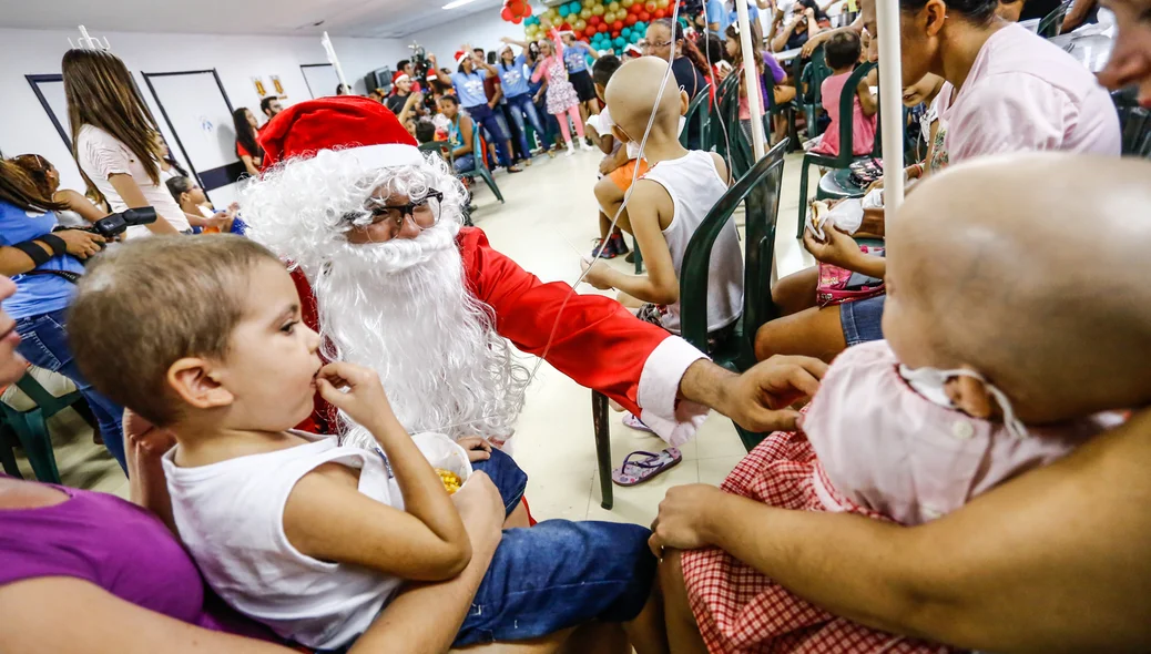 Papai Noel dando carinho as crianças com câncer 