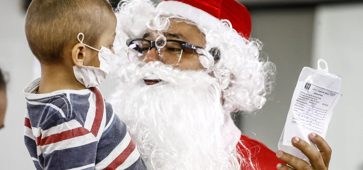 Criança recebendo o carinho do Papai Noel 