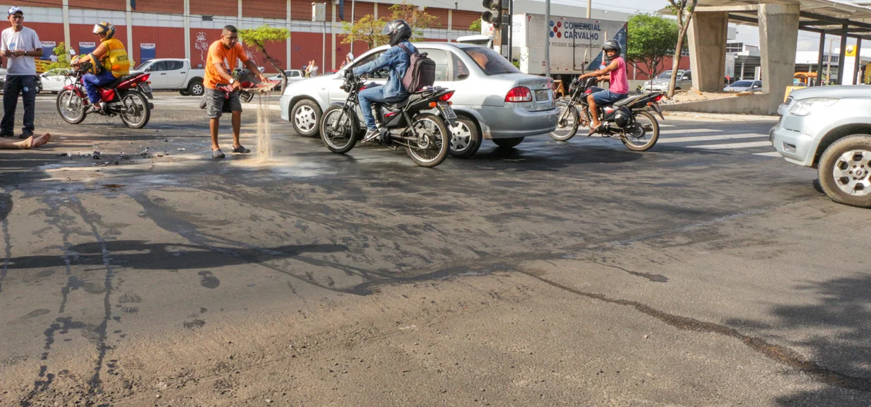 Populares jogando areia na pista para neutralizar o óleo derramado