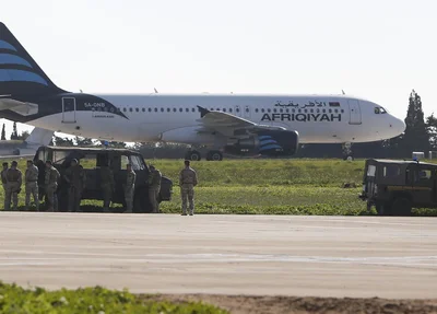 Tropas acompanham a inspeção do avião no aeroporto de Malta