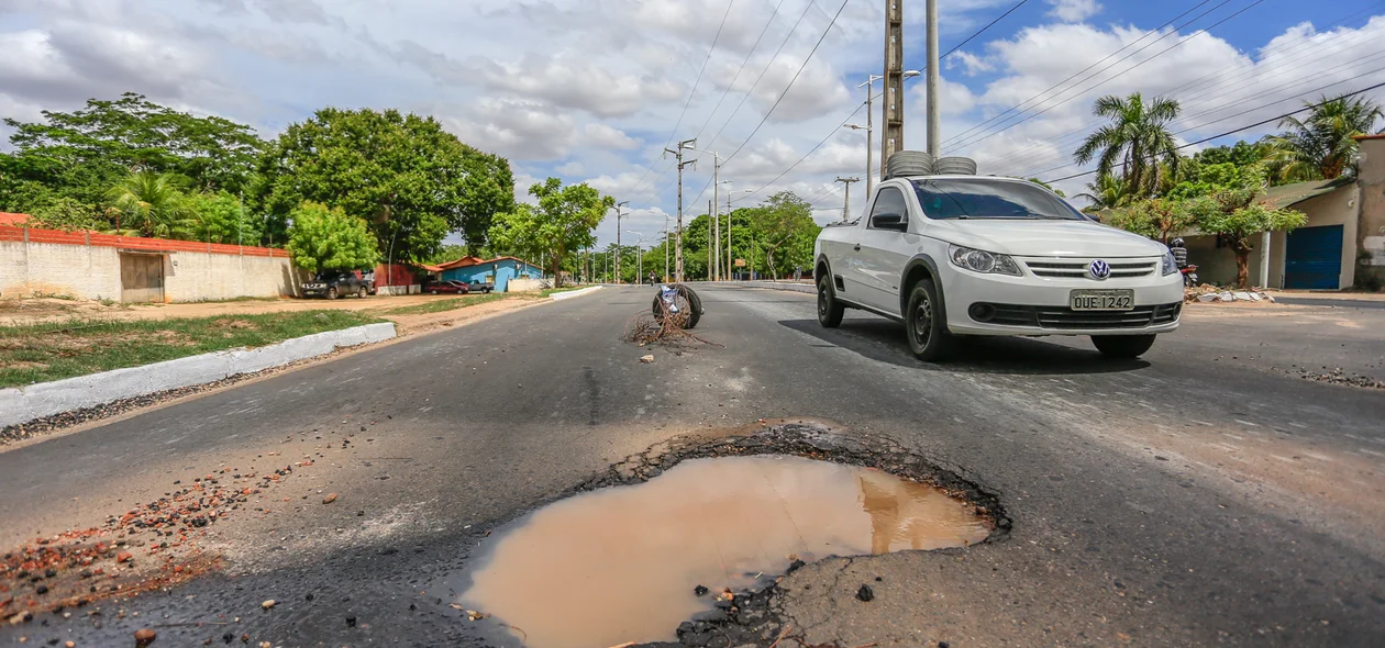 Carros desviando do buraco