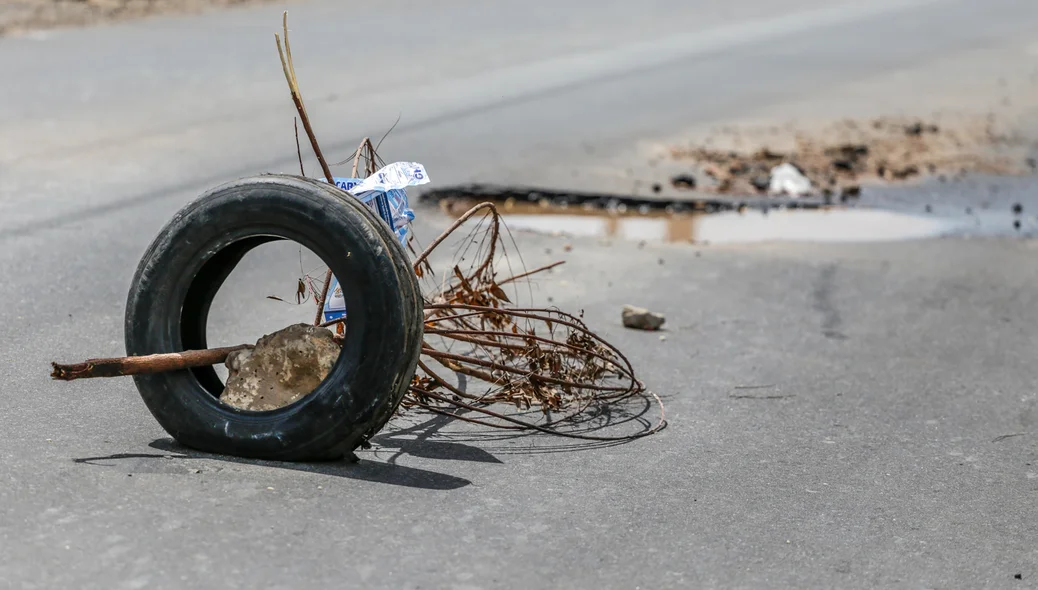 Moradores colocaram galhos e um pneu para alertar sobre o buraco