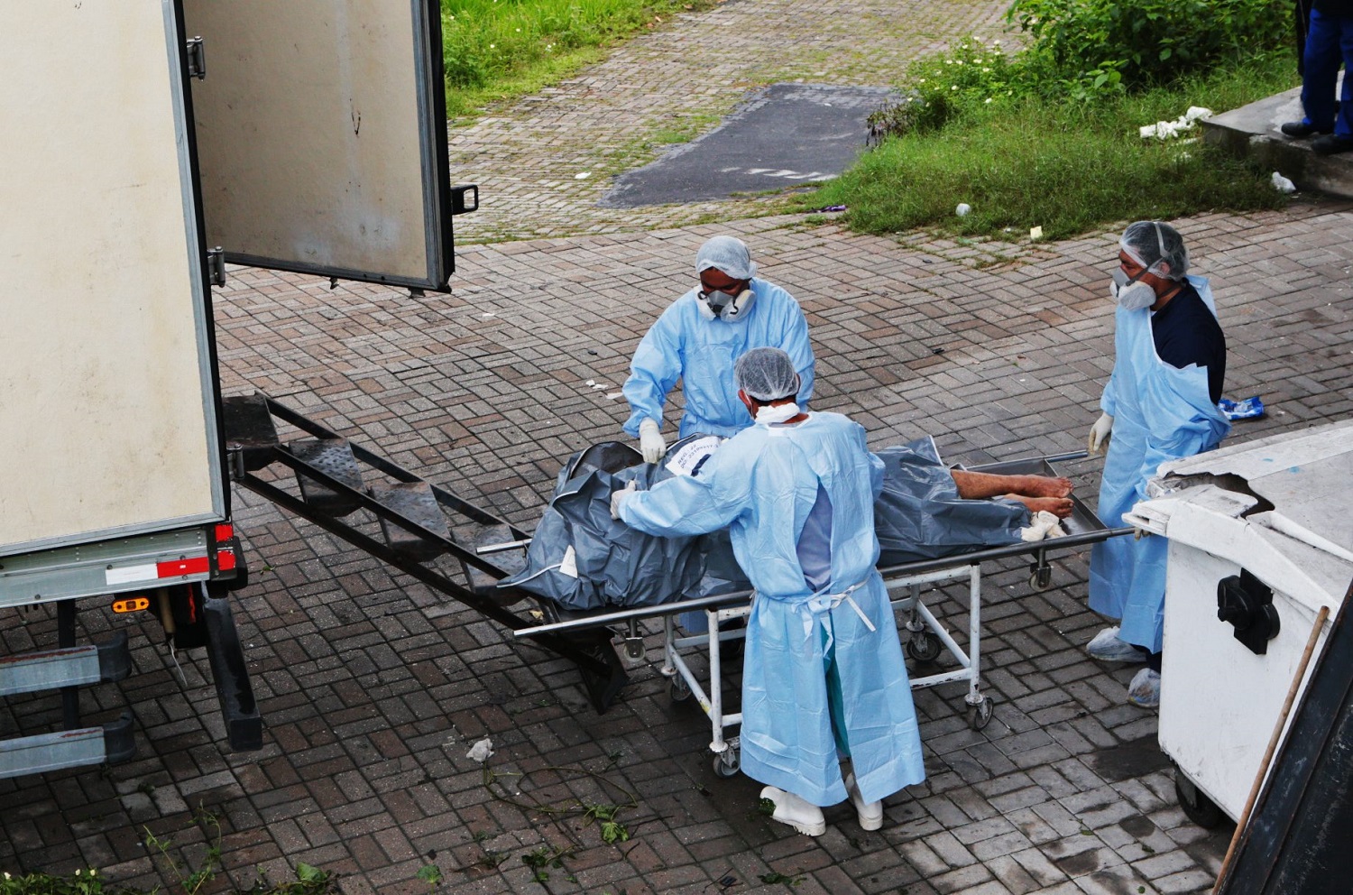 Funcionários do Instituto Médico Legal (IML) colocam corpos de presos em um caminhão
