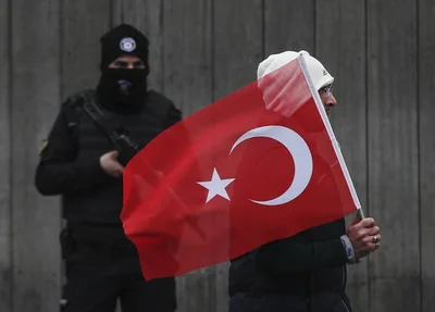 Turco passa em frente à boate alvo do atentato com a bandeira do país
