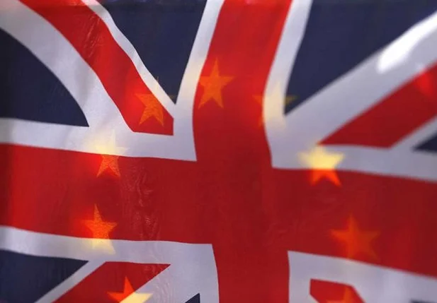 Bandeira britânica fotografada em frente à bandeira europeia