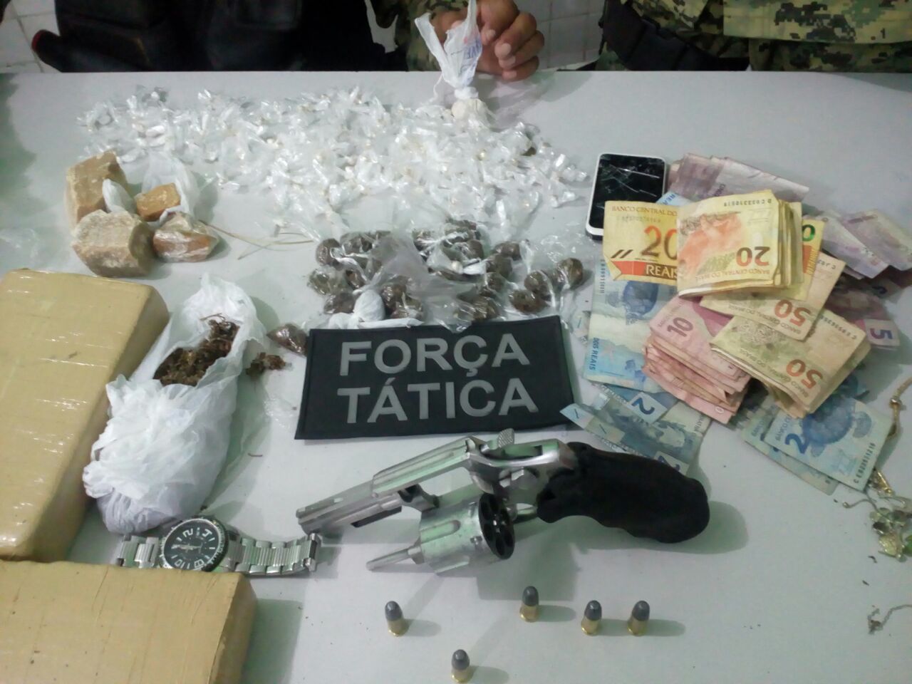 Drogas, dinheiro, arma e objetos apreendidos na residência