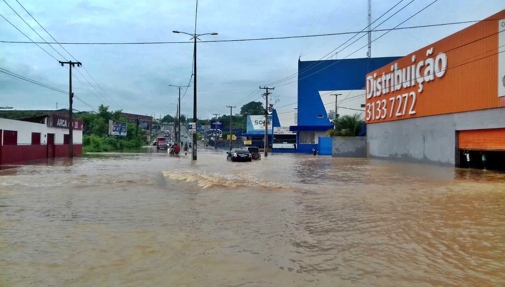 Carros tentam passar pelo trecho alagado