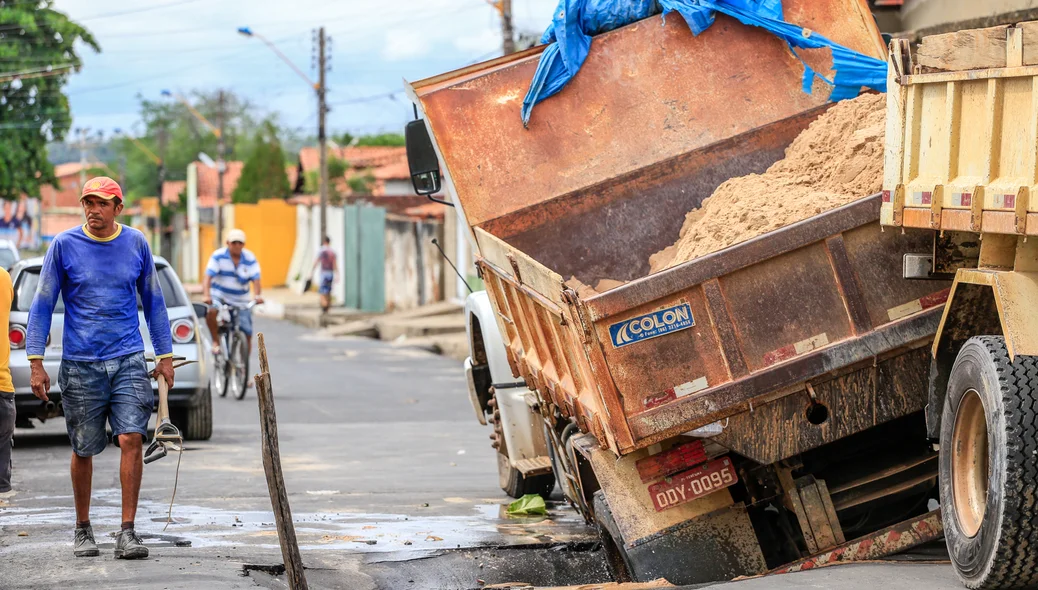 Funcionários da empresa tentando recuperar a carga que estava no caminhão