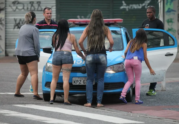Mulheres tentam evitar a saída de viaturas da PM no Rio