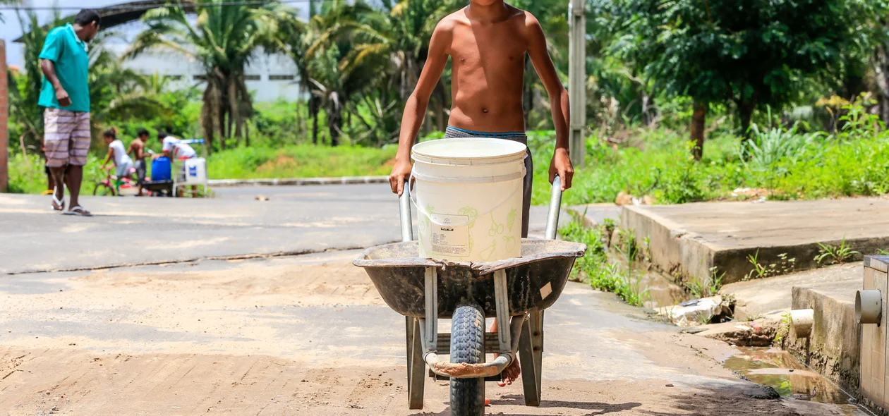Criança carregando água para sua casa