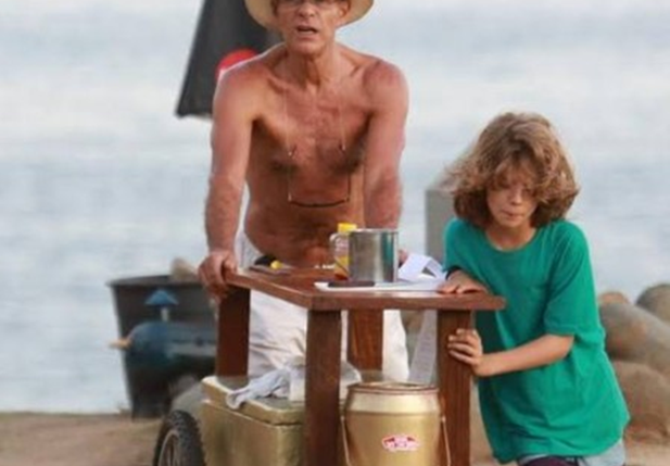 Ator Mário Gomes vendendo hambúrguer na praia com seu filho