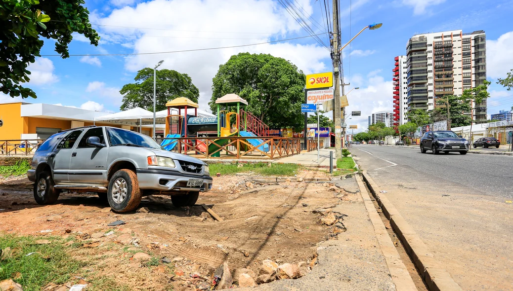 Carro com dificuldade de passar pela rua 