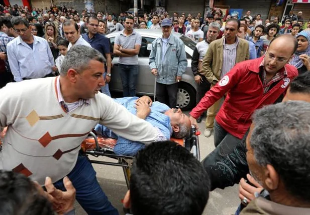 Vítima é carregada após explosão em igreja cristã copta, em Tanta, no Egito