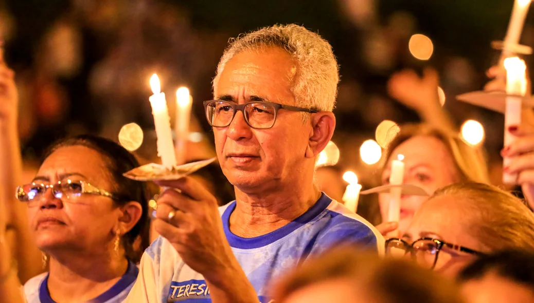 Homem segura vela durante a missa