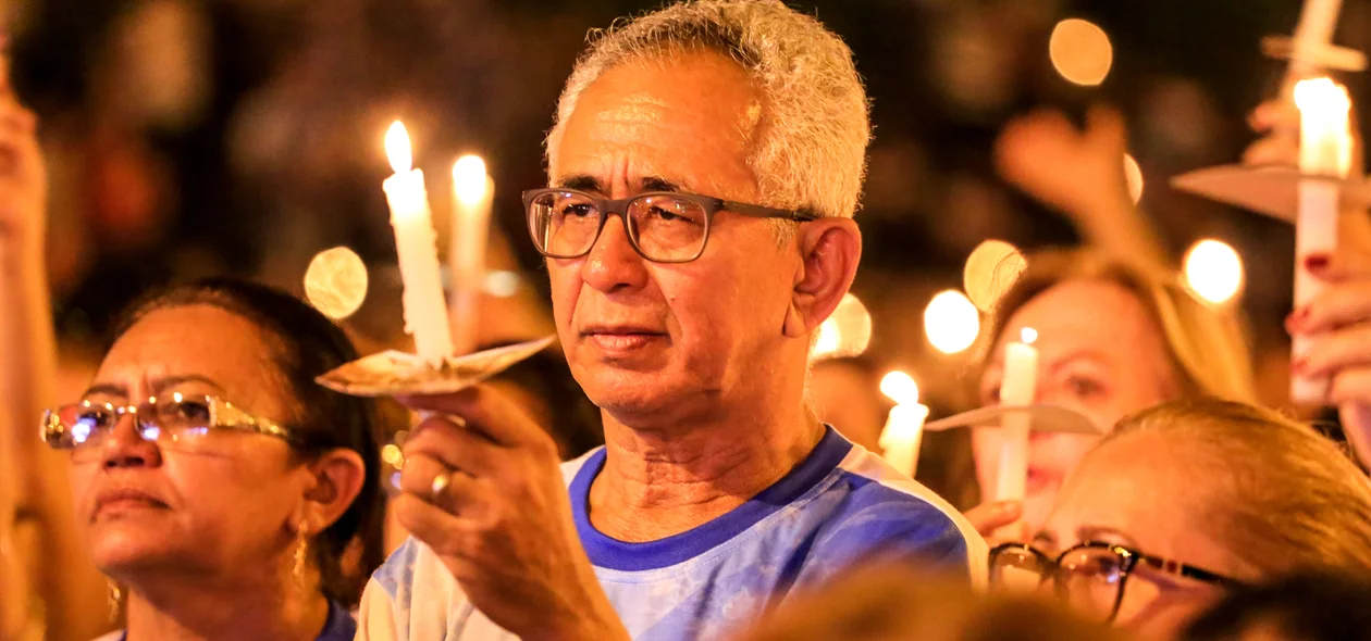Homem segura vela durante a missa