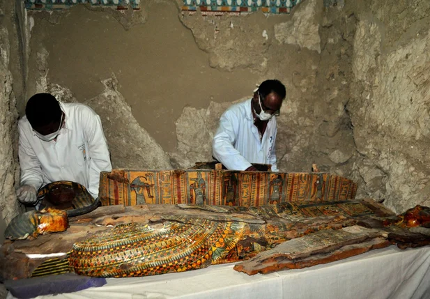 Membros da equipe de arqueólogos do Egito trabalham em sarcófago de madeira