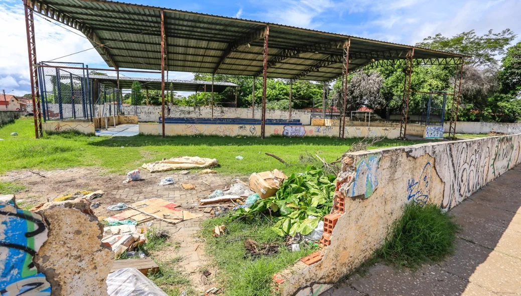 Espaço externo da quadra tomado por lixo.