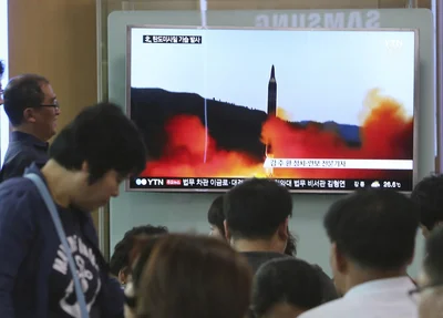   Pessoas assistem a programa de TV que mostra míssil lançado pela Coreia do Norte