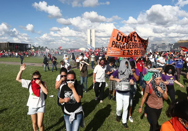 Manifestantes tentam fugir na fumaça das bombas de gás lacrimogênio 