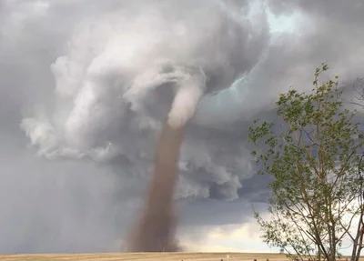 Homem corta grama enquanto tornado se aproxima