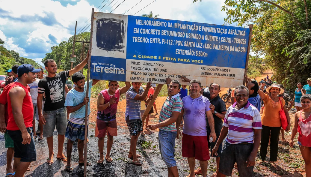 Moradores mostram a placa de melhorias no povoado 