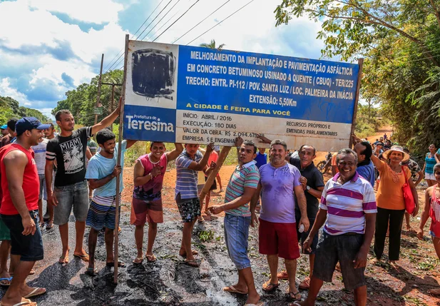 Moradores mostram a placa de melhorias no povoado 